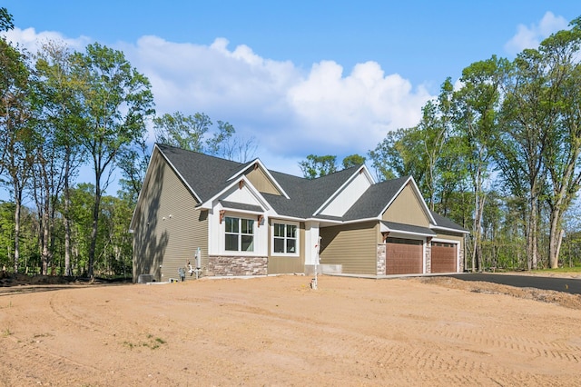 14633 Packard St NE, Ham Lake, MN 55304 - craftsman-style home with stone siding, dirt driveway, and a garage