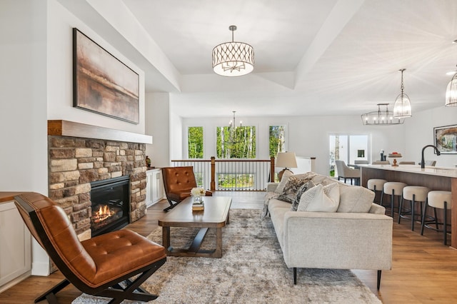 14633 Packard St NE, Ham Lake, MN 55304 - living room with a chandelier, light wood finished floors, a fireplace, and a raised ceiling