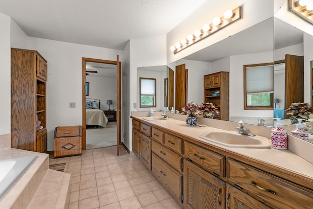 9755 Egret Blvd NW, Coon Rapids, MN 55433 - ensuite bathroom with double vanity, tile patterned floors, a bath, and a textured ceiling