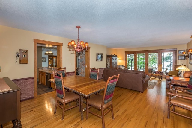 22855 Lake Hubert Dr, Lake Edward Twp, MN 56401 - dining space featuring light wood finished floors, a chandelier, and a textured ceiling