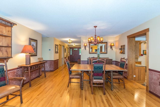 22855 Lake Hubert Dr, Lake Edward Twp, MN 56401 - dining space with light wood finished floors, wainscoting, and a chandelier