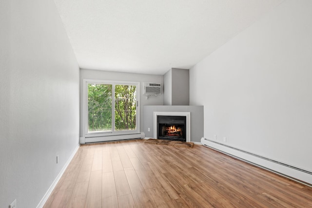 3425 Golfview Dr Unit 308, Eagan, MN 55123 - unfurnished living room featuring a baseboard heating unit, wood finished floors, a lit fireplace, and an AC wall unit