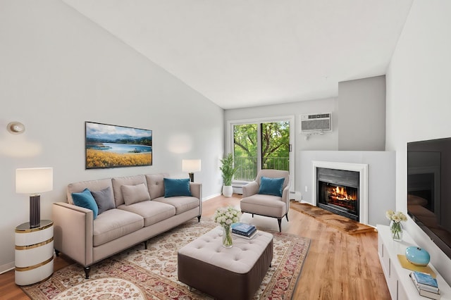3425 Golfview Dr Unit 308, Eagan, MN 55123 - living area with a lit fireplace, wood finished floors, a wall mounted air conditioner, lofted ceiling, and a baseboard heating unit