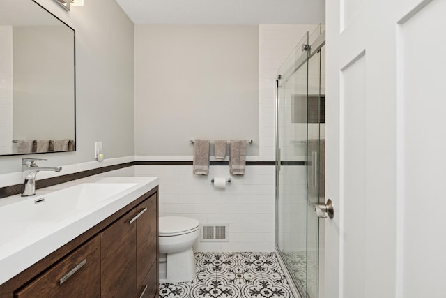 14933 Echo Way, Apple Valley, MN 55124 - full bathroom featuring toilet, a shower stall, tile walls, vanity, and tile patterned floors