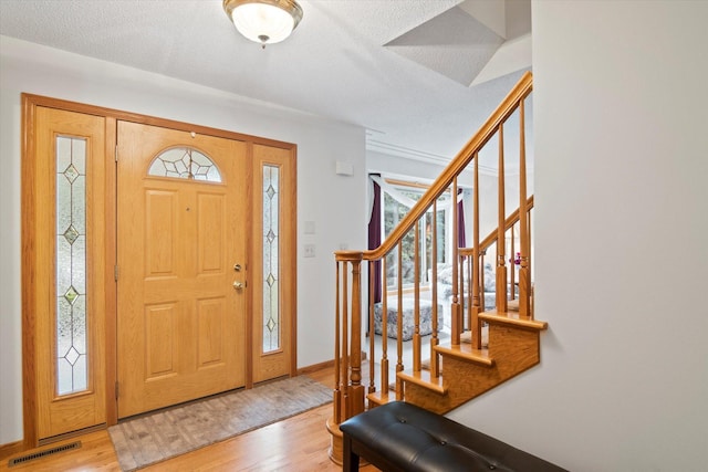 12351 Holly St NW, Coon Rapids, MN 55448 - foyer entrance featuring light wood-style flooring, stairway, and healthy amount of natural light