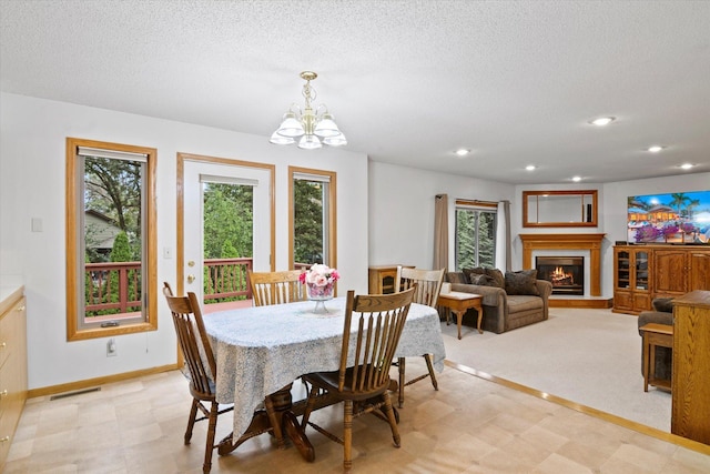 12351 Holly St NW, Coon Rapids, MN 55448 - dining space with light floors, plenty of natural light, a chandelier, a glass covered fireplace, and a textured ceiling