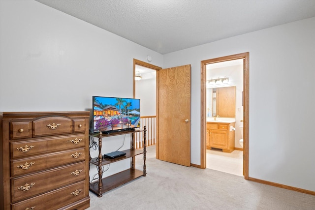 12351 Holly St NW, Coon Rapids, MN 55448 - bedroom featuring light carpet, ensuite bathroom, baseboards, a sink, and a textured ceiling