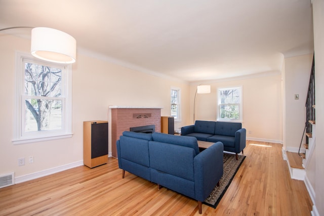 1904 Saunders Ave, Saint Paul, MN 55116 - living room featuring light wood finished floors, baseboards, stairway, and a brick fireplace