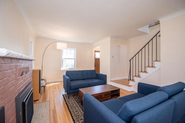 1904 Saunders Ave, Saint Paul, MN 55116 - living room featuring a tiled fireplace, light wood-style flooring, stairs, and baseboards