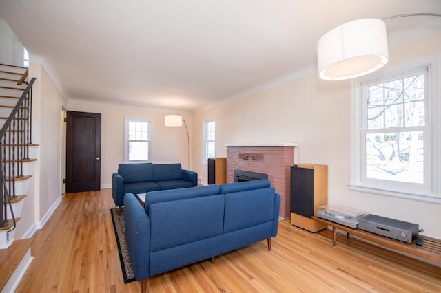 1904 Saunders Ave, Saint Paul, MN 55116 - living room with stairs, light wood-type flooring, a brick fireplace, and baseboards