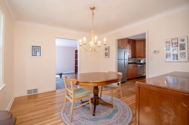 1904 Saunders Ave, Saint Paul, MN 55116 - dining area with a chandelier, light wood-style flooring, and baseboards
