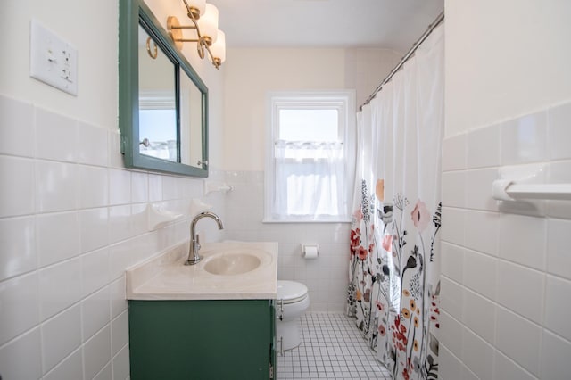 1904 Saunders Ave, Saint Paul, MN 55116 - bathroom with tile walls, tile patterned flooring, toilet, vanity, and a wainscoted wall