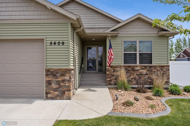 5409 47th Ave S, Fargo, ND 58104 - view of front of home with stone siding, an attached garage, and entry steps