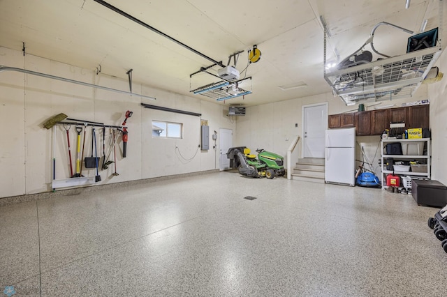 5409 47th Ave S, Fargo, ND 58104 - garage featuring freestanding refrigerator, electric panel, and a garage door opener