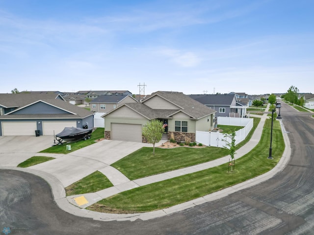 5409 47th Ave S, Fargo, ND 58104 - view of front facade with concrete driveway, a residential view, an attached garage, and stone siding