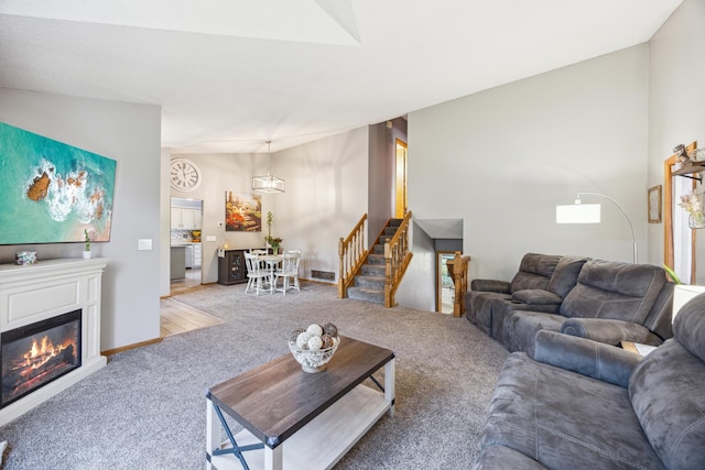 1435 104th Ln NW, Coon Rapids, MN 55433 - living room featuring carpet floors, stairs, a glass covered fireplace, and lofted ceiling