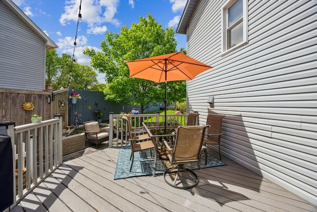 1435 104th Ln NW, Coon Rapids, MN 55433 - wooden deck with outdoor dining area and a fenced backyard