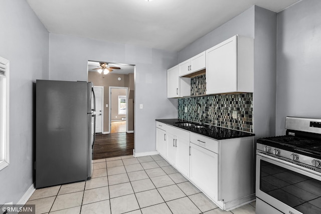 485 Belvidere St E, Saint Paul, MN 55107 - kitchen with stainless steel appliances, a sink, ceiling fan, dark countertops, and white cabinetry
