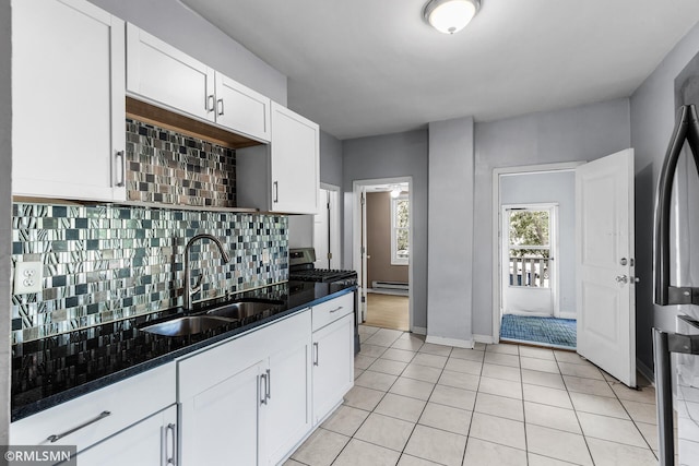 485 Belvidere St E, Saint Paul, MN 55107 - kitchen featuring a sink, stainless steel gas range, baseboard heating, light tile patterned floors, and white cabinets