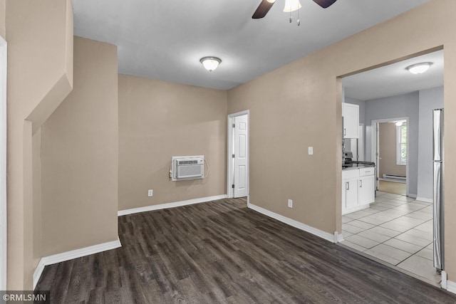 485 Belvidere St E, Saint Paul, MN 55107 - empty room with a wall mounted AC, baseboard heating, ceiling fan, wood finished floors, and baseboards