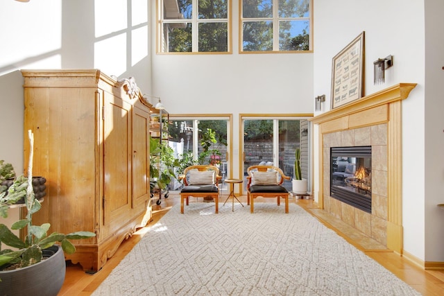 10014 Cove Dr, Hopkins, MN 55305 - sitting room featuring a towering ceiling, plenty of natural light, wood finished floors, and a tile fireplace