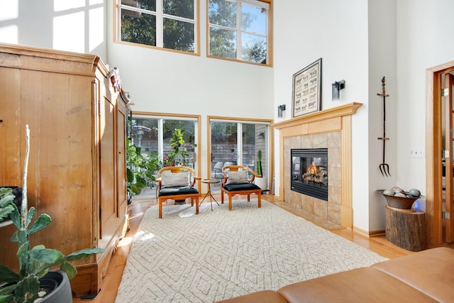10014 Cove Dr, Hopkins, MN 55305 - living room featuring a towering ceiling, plenty of natural light, a tile fireplace, and light wood-style floors