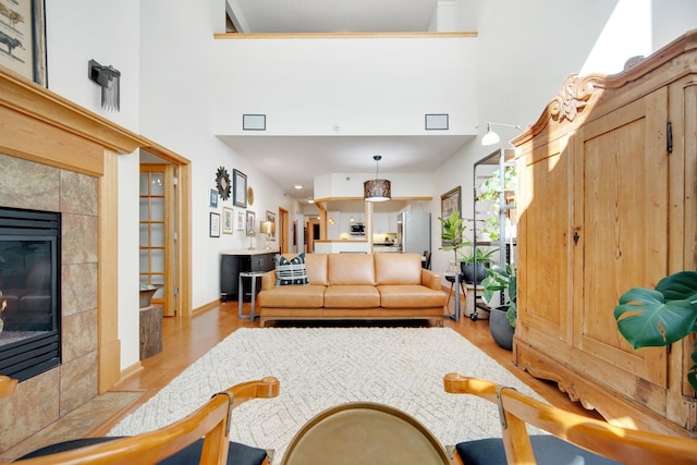 10014 Cove Dr, Hopkins, MN 55305 - living room featuring a towering ceiling, light wood finished floors, a fireplace, and baseboards