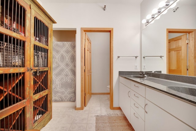 10014 Cove Dr, Hopkins, MN 55305 - bathroom with toilet, tile patterned flooring, double vanity, and baseboards
