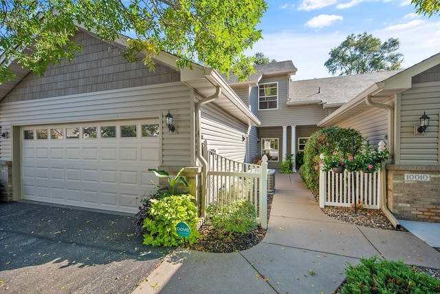 10014 Cove Dr, Hopkins, MN 55305 - view of front facade with asphalt driveway and a garage