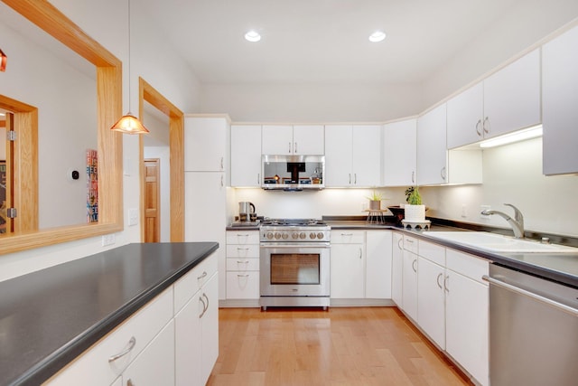 10014 Cove Dr, Hopkins, MN 55305 - kitchen with appliances with stainless steel finishes, a sink, dark countertops, light wood-style flooring, and white cabinets