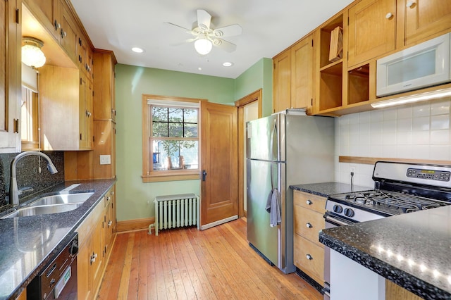 kitchen featuring radiator, a sink, appliances with stainless steel finishes, open shelves, and ceiling fan
