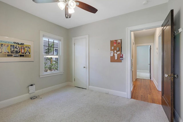 unfurnished bedroom featuring carpet flooring, baseboards, and a ceiling fan
