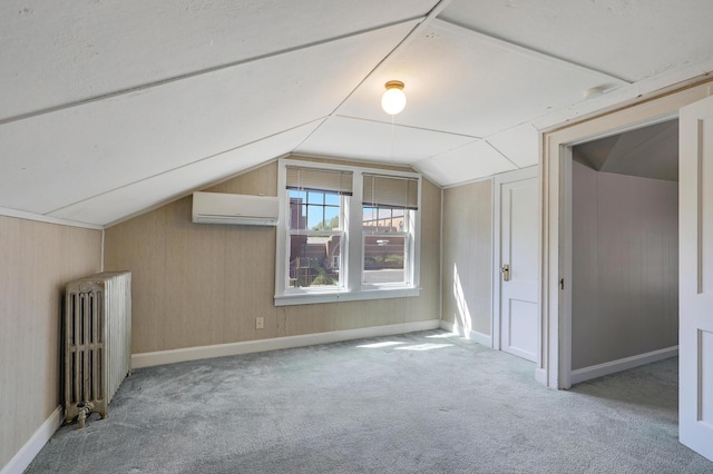 bonus room featuring radiator heating unit, a wall unit AC, lofted ceiling, carpet, and baseboards