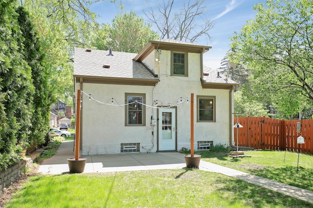 rear view of house featuring stucco siding, roof with shingles, and a patio area