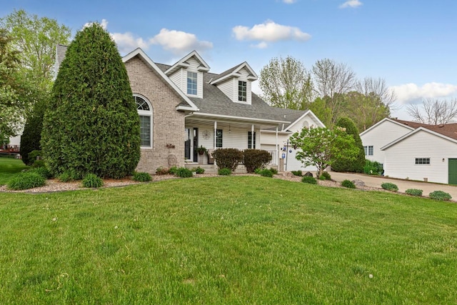 view of front of home featuring a front yard, a porch, and brick siding