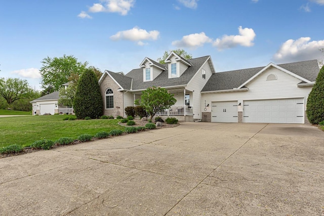 view of front of property featuring a garage, driveway, a front yard, a shingled roof, and a porch