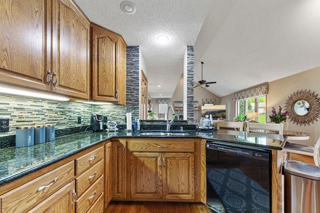 kitchen with dishwasher, a sink, ceiling fan, a textured ceiling, and wood finished floors