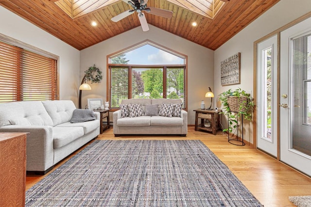 living room with a skylight, light wood-style floors, wooden ceiling, ceiling fan, and baseboards
