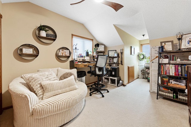 carpeted home office with lofted ceiling, ceiling fan, and healthy amount of natural light