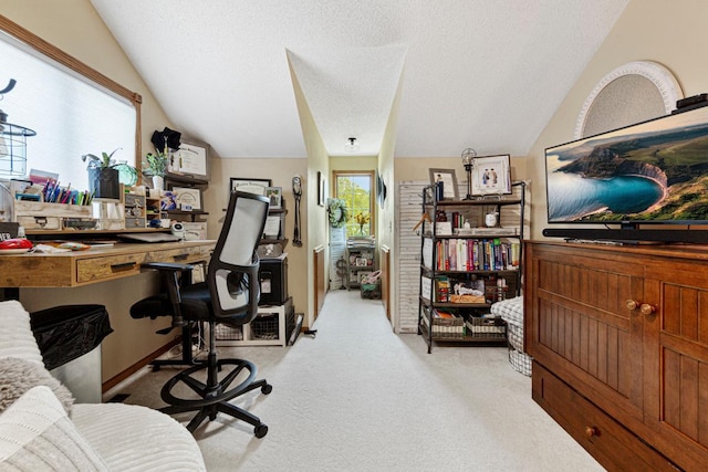 carpeted home office with a textured ceiling and vaulted ceiling