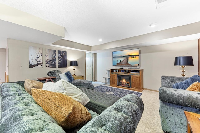 living area featuring carpet flooring, baseboards, a glass covered fireplace, and recessed lighting