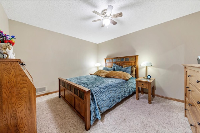 bedroom featuring light carpet, baseboards, a textured ceiling, and a ceiling fan