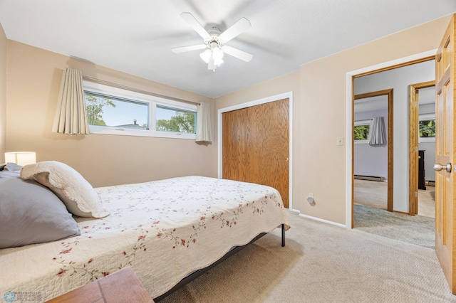 2514 Willow Rd N, Fargo, ND 58102 - bedroom featuring a baseboard radiator, a closet, light carpet, baseboards, and a ceiling fan