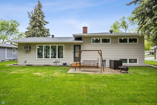 2514 Willow Rd N, Fargo, ND 58102 - back of property with a chimney, a patio, a lawn, a wall unit AC, and a fire pit