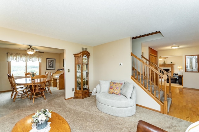 4822 3rd St NW, Rochester, MN 55901 - carpeted living room with a ceiling fan, stairway, baseboards, and a textured ceiling