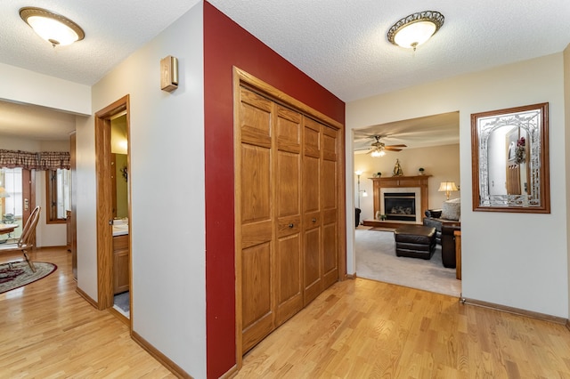 4822 3rd St NW, Rochester, MN 55901 - corridor with light wood-style flooring, a textured ceiling, and baseboards