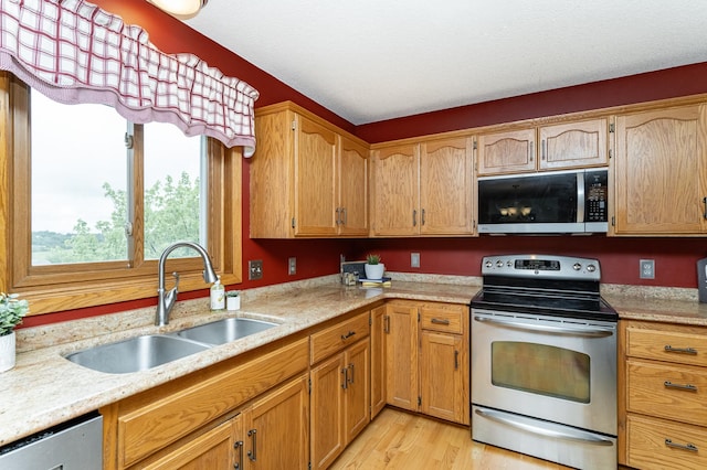 4822 3rd St NW, Rochester, MN 55901 - kitchen with appliances with stainless steel finishes, a sink, and light wood-type flooring