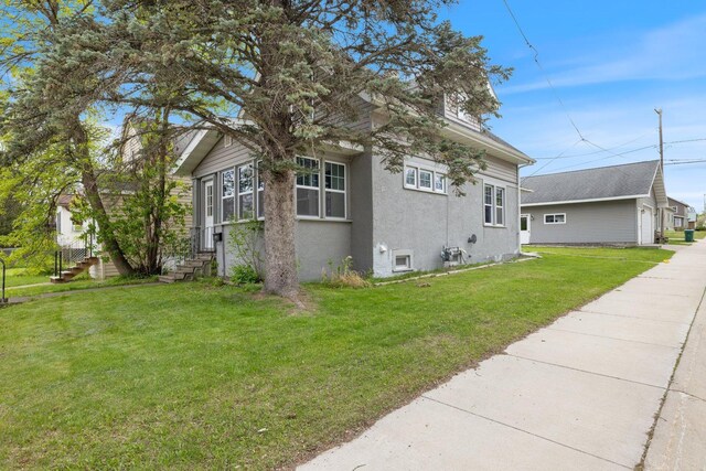 301 3rd St, Nashwauk, MN 55769 - view of side of property featuring stucco siding and a lawn
