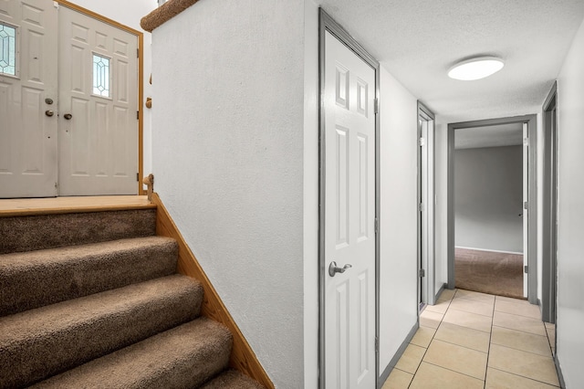 1653 Briardale Rd NE, Fridley, MN 55432 - stairway featuring a textured wall, tile patterned floors, a textured ceiling, and baseboards