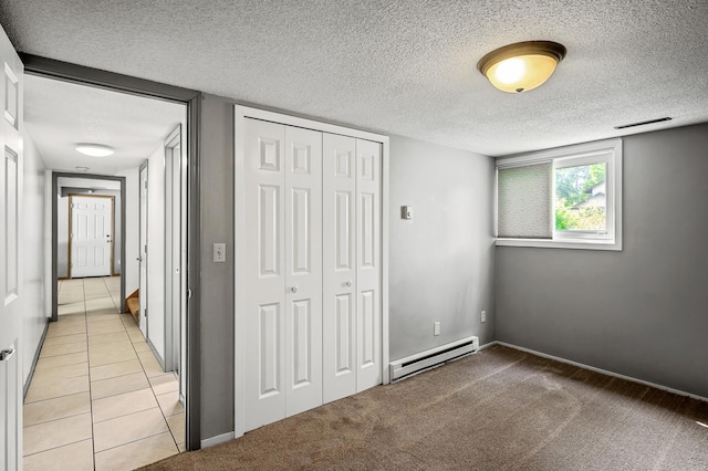 1653 Briardale Rd NE, Fridley, MN 55432 - unfurnished bedroom with a baseboard heating unit, a textured ceiling, a closet, light carpet, and light tile patterned floors